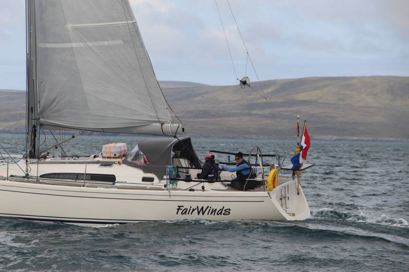 De FairWinds onder zeil langs een ruige kust op de noordelijke Noordzee